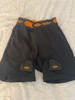 Youth Black Protective Hockey Shorts with Orange Accents